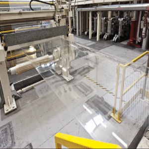 A roll of transparent, glossy biodegradable plastic film unfurled on a flat surface, representing eco-friendly packaging material.