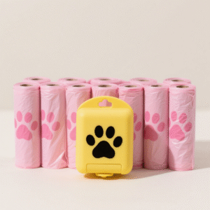 Pink biodegradable pet waste bag rolls are neatly arranged, and the yellow dispenser with a black paw print highlights the product set and easy access design.