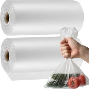 Two rolls of white biodegradable fruit and vegetable bags. The right hand is holding a transparent bag full of fruits and vegetables. The green vegetables and red fruits are clearly visible, showing the product usage scenario.