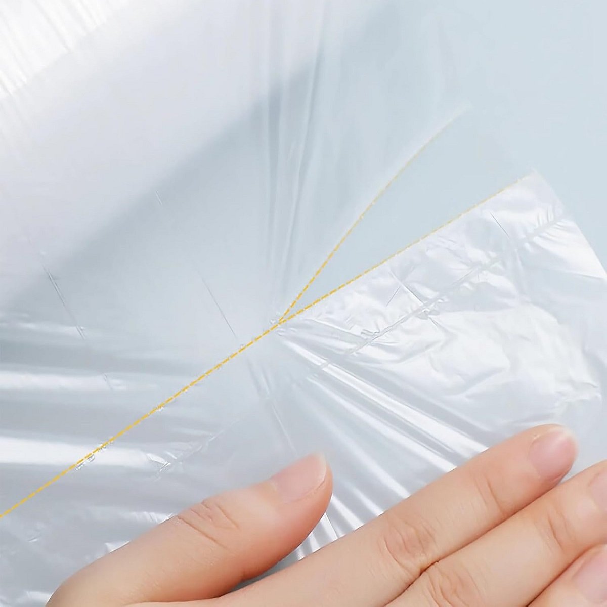 Two rolls of white biodegradable fruit and vegetable bags on the left, and a transparent bag full of oranges on the right, show the product form and usage scenarios.