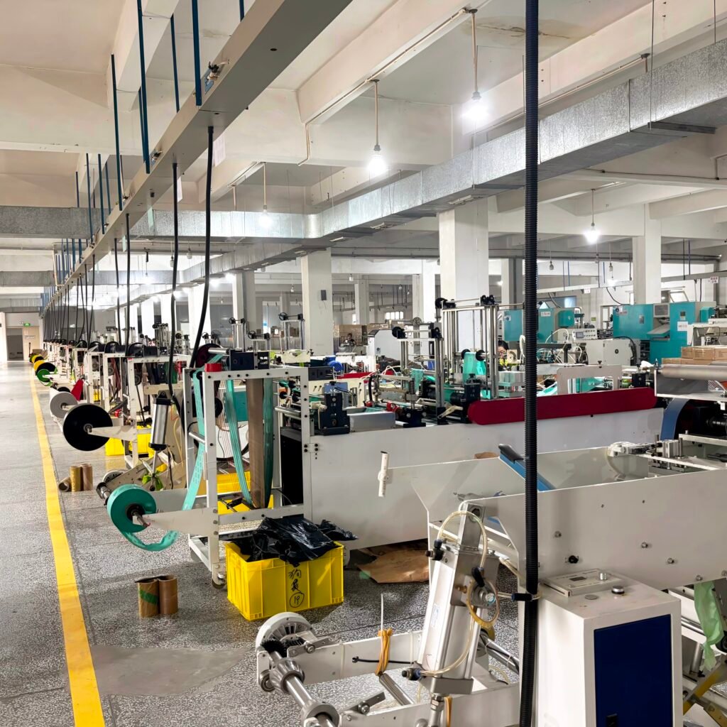 Plastic bag manufacturing factory, automated production line, industrial packaging machinery, factory workshop, manufacturing equipment.
