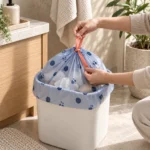 Hands supporting and closing a small compostable drawstring bag during changeover